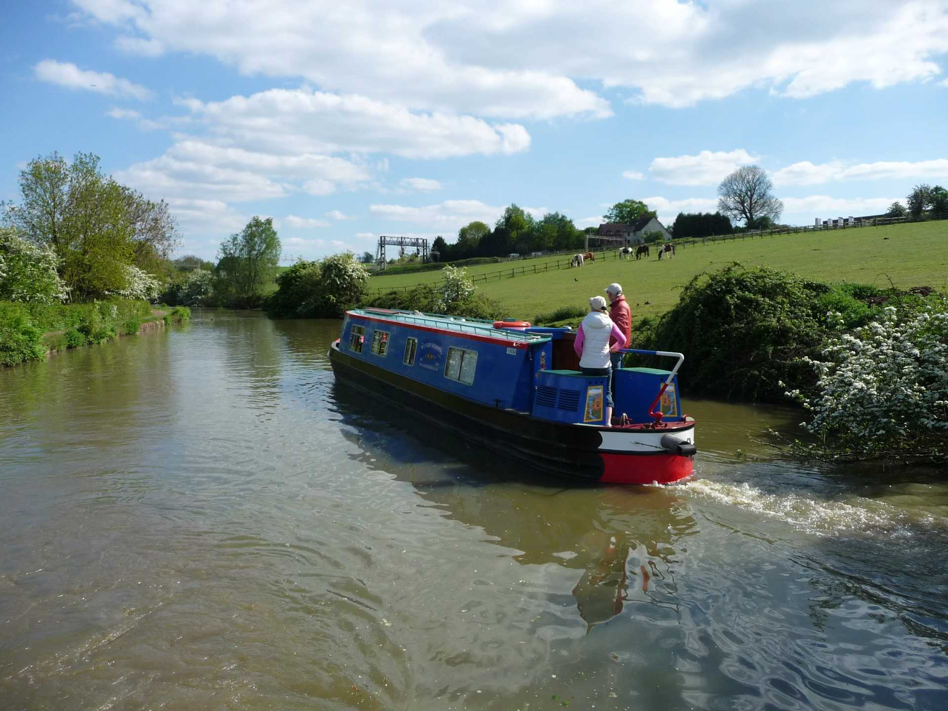  a blue wyvern narrow boat in a lock with a bridge and cottage