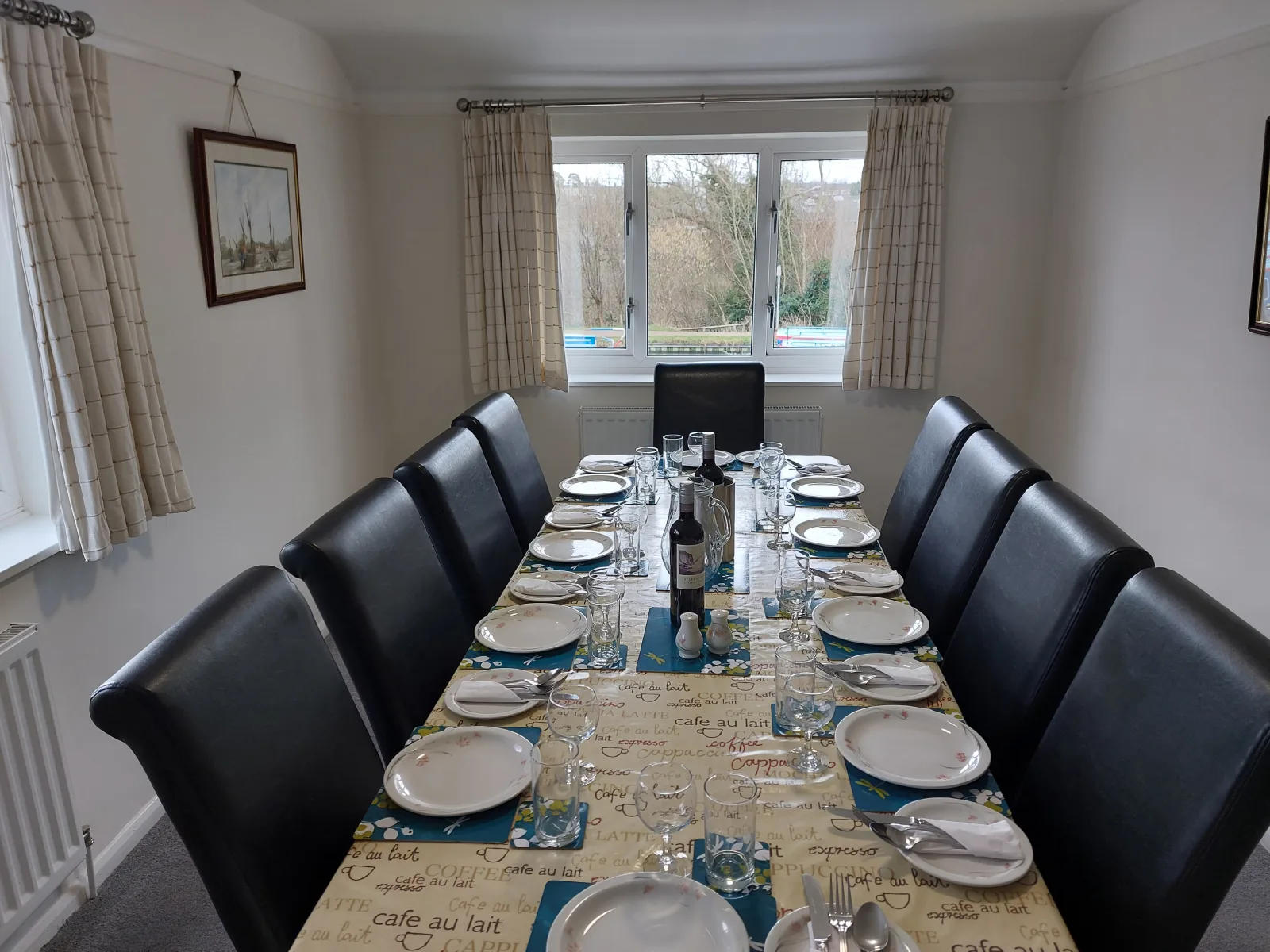 Dining room at Waterside Cottage laid for twelve with black leather chairs