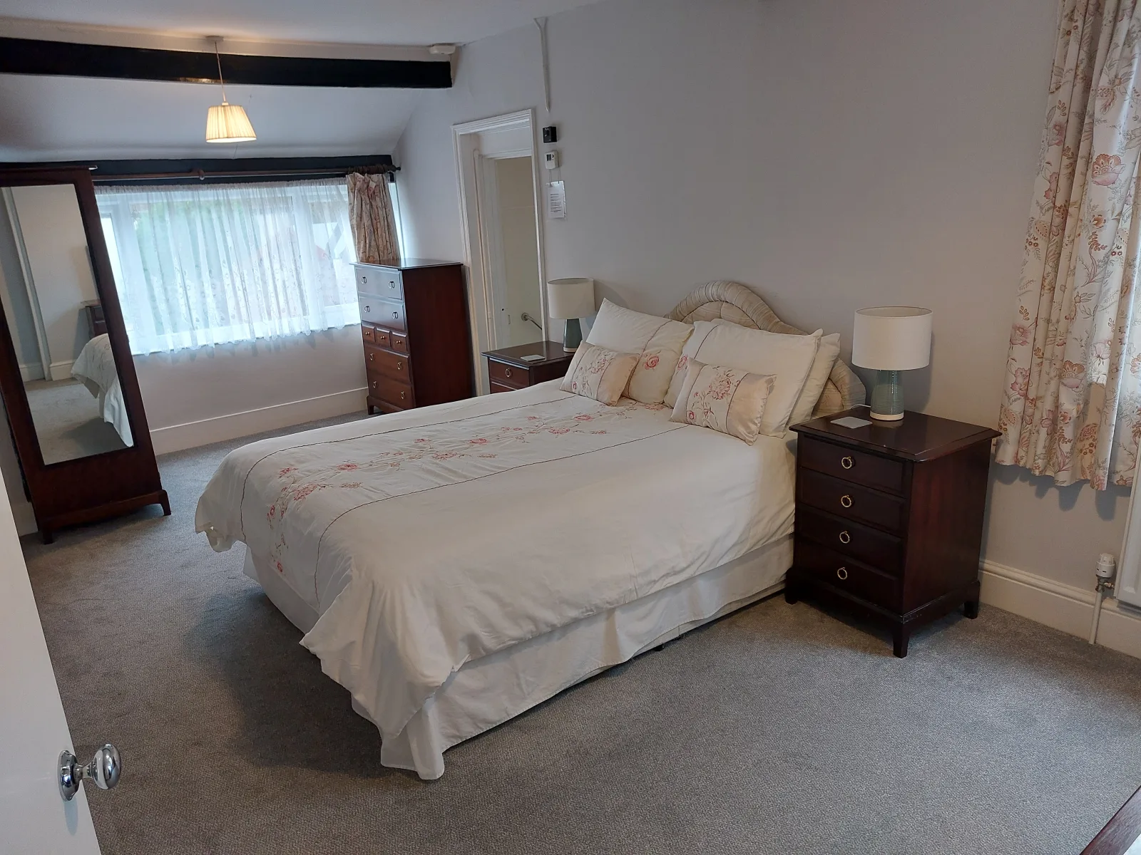 Double bedroom at Waterside Cottage with a mirrored wardrobe and bedside lamps