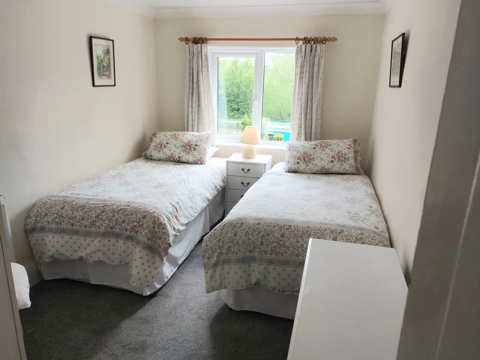 Twin bedroom at Waterside Cottage with two single beds and a window between them