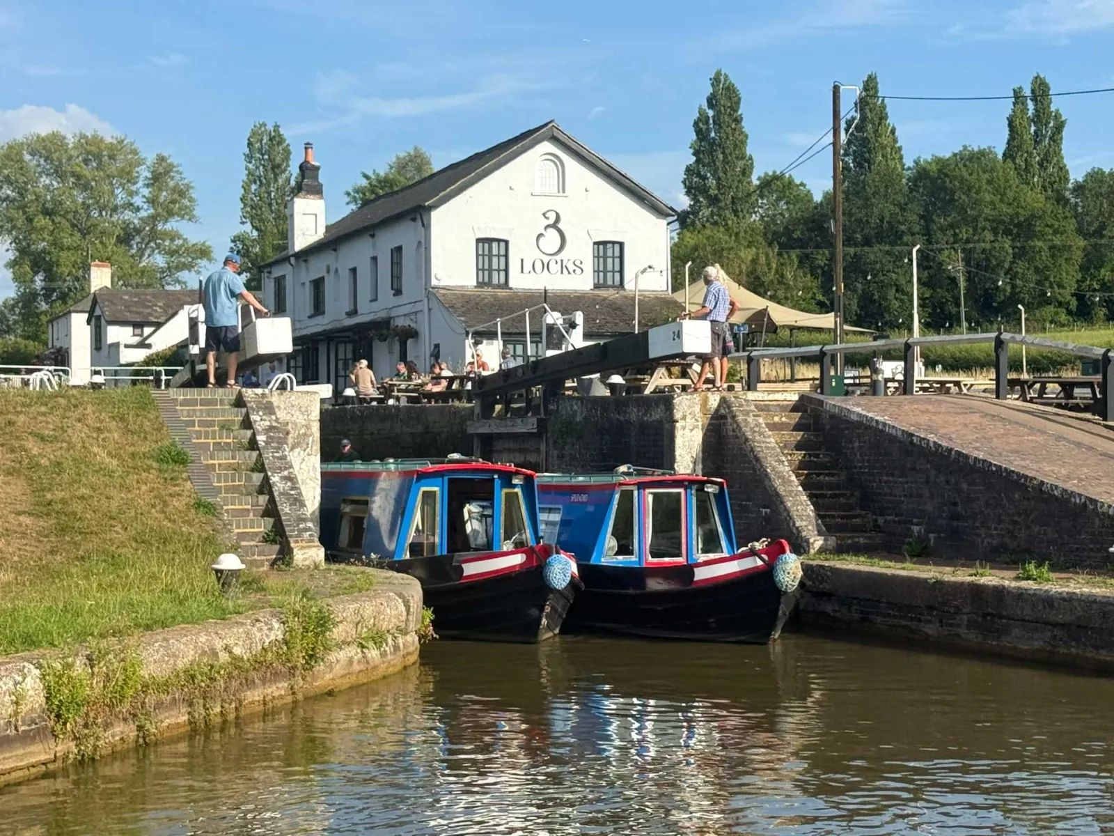 Narrowboats moored below the Three Locks at Soulbury with the canalside pub behind