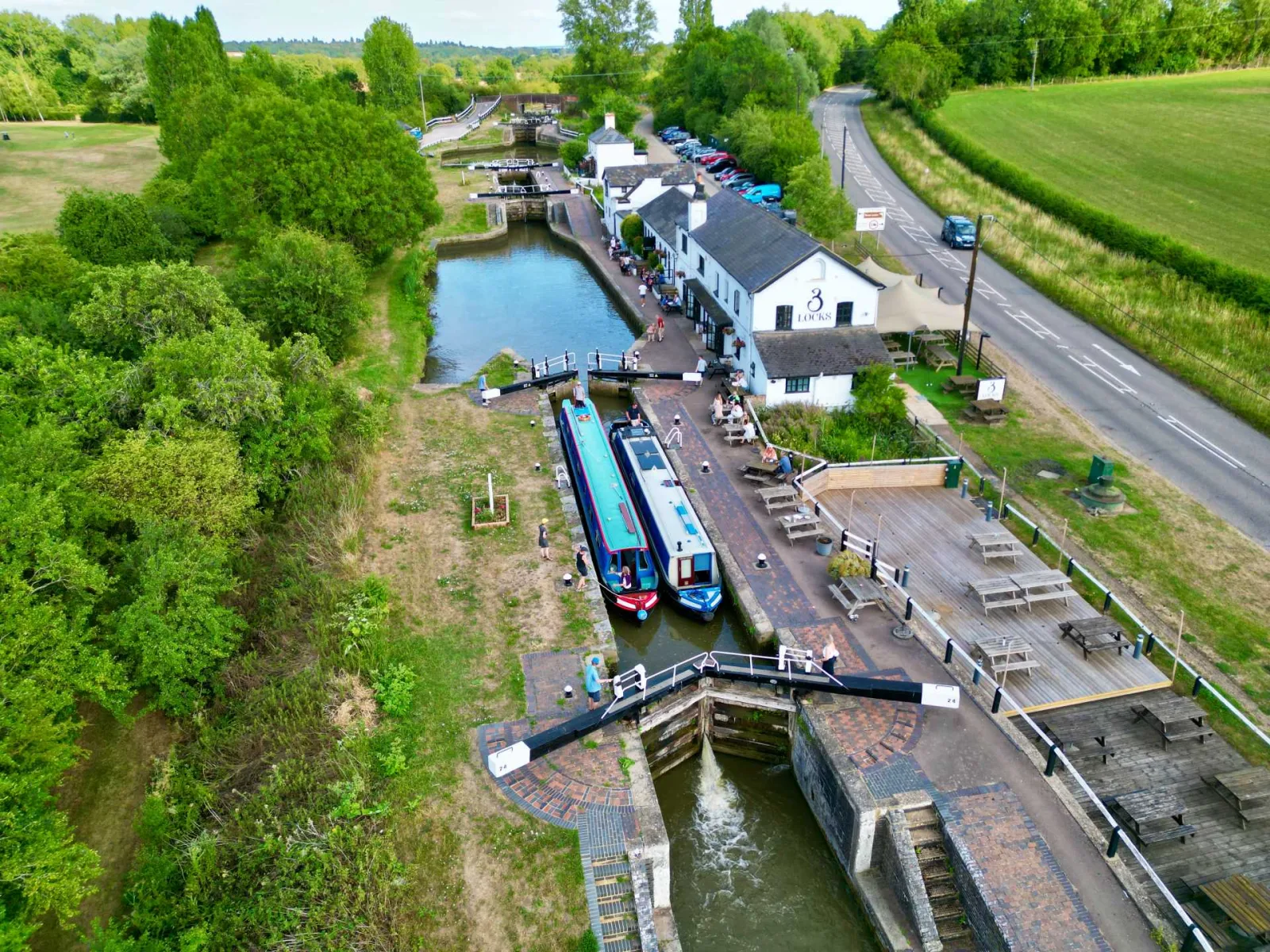 Aerial view of the Three Locks flight at Soulbury with narrowboats in the locks and a pub alongside