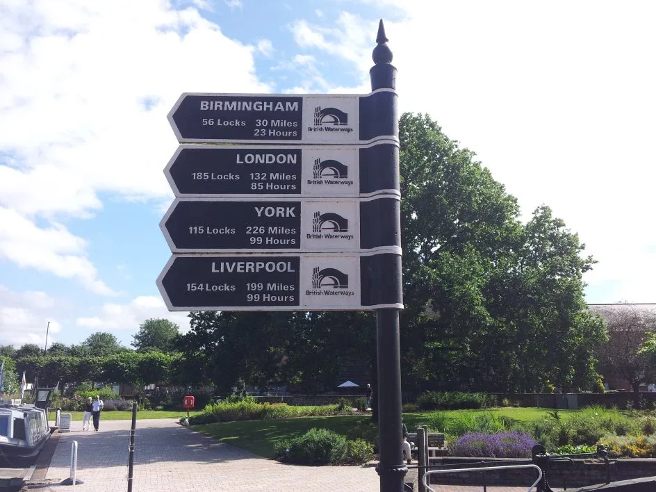 Canal signpost giving the locks miles and hours to Birmingham London York and Liverpool