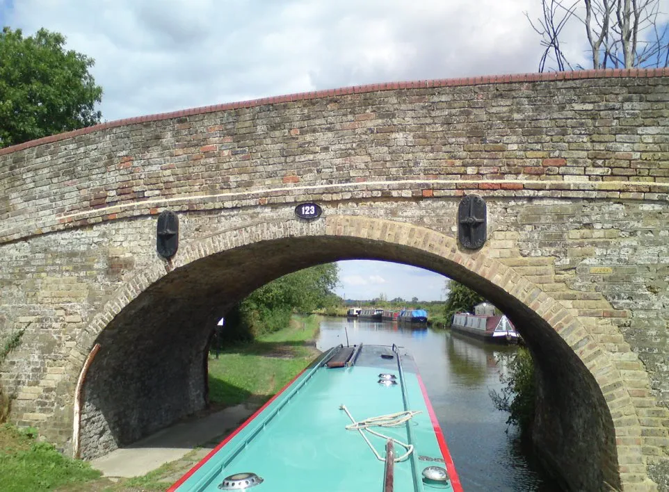 Brick canal bridge seen from the roof of a narrowboat about to pass beneath it