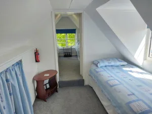 Single loft bedroom at Waterside Cottage with a sloping ceiling and a doorway through