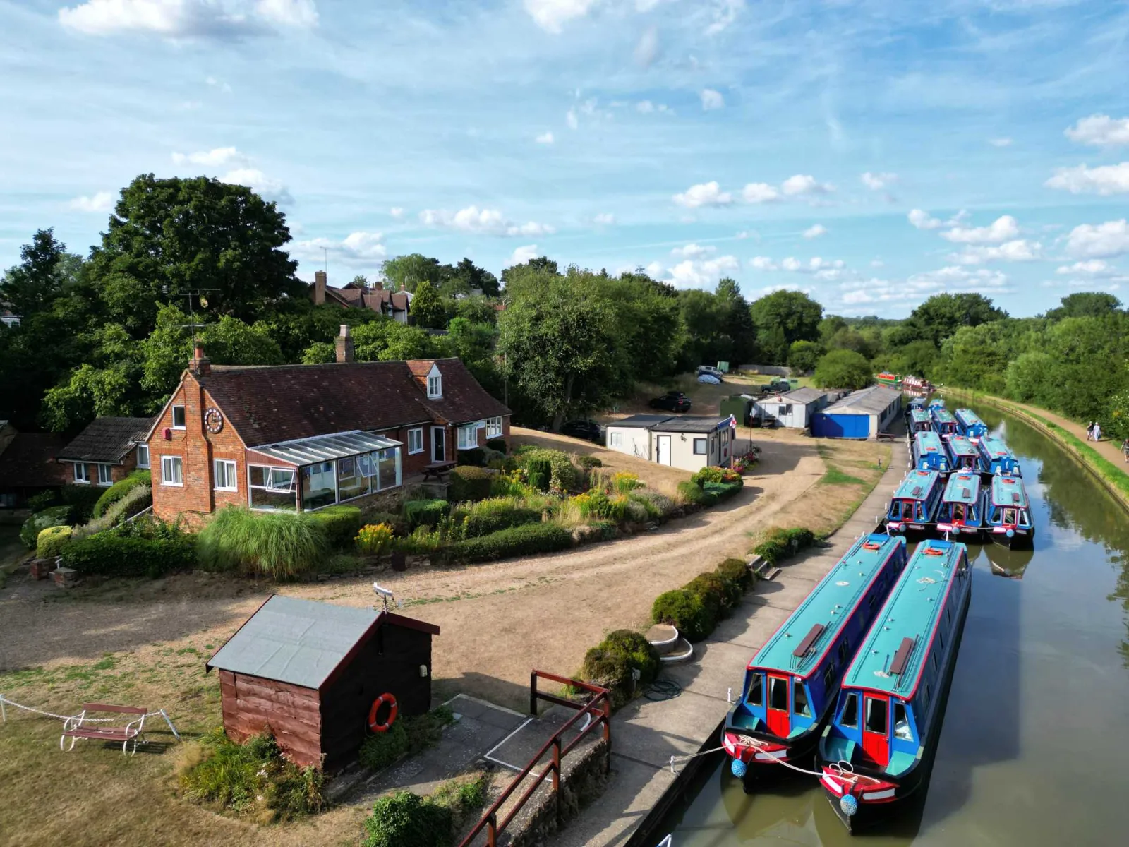 Aerial view of Waterside Cottage beside the canal with the boatyard and moored narrowboats