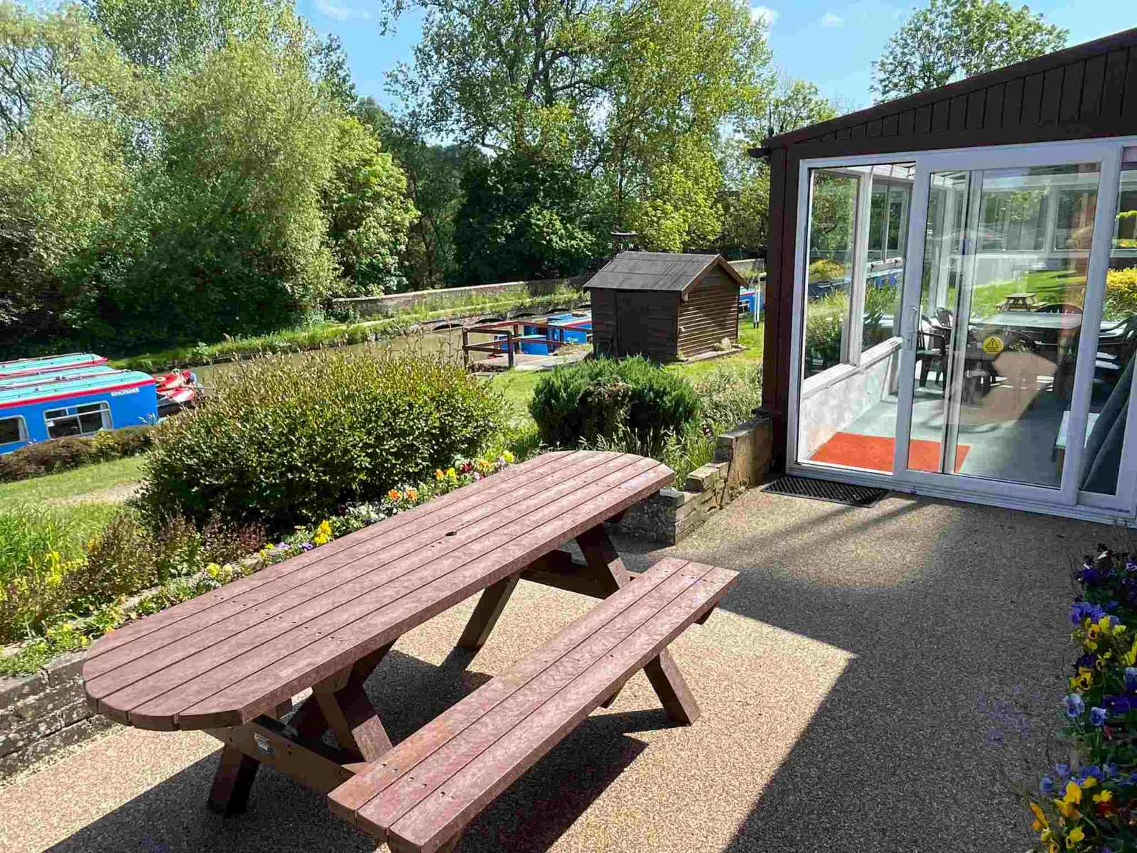 Picnic table on the terrace beside the conservatory at Waterside Cottage