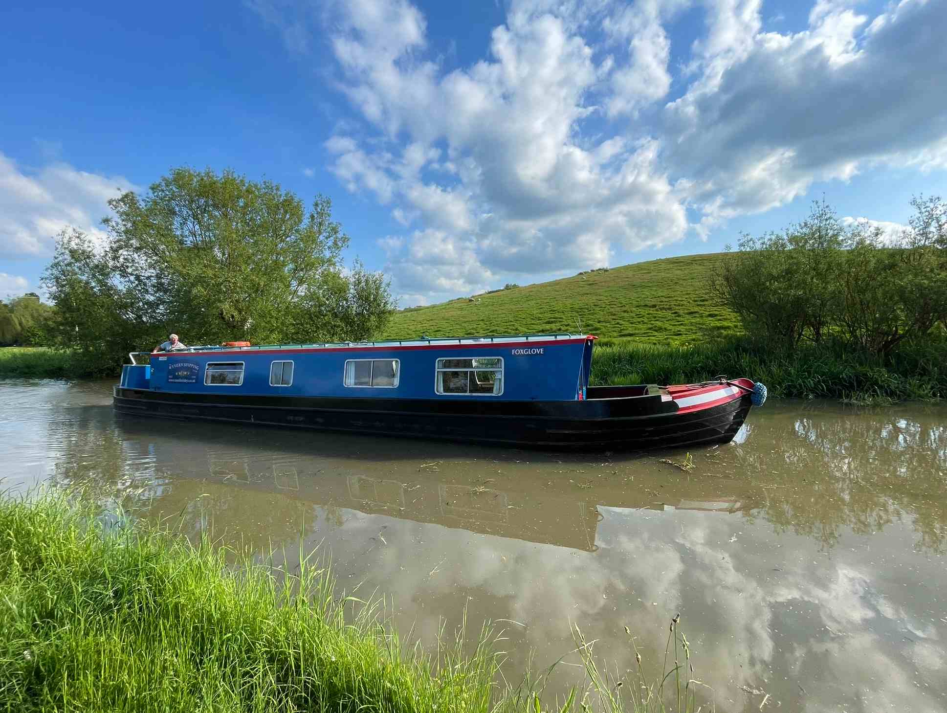  blue wyvern boat approaching a stone bridge