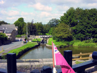 Leaving a narrow lock from stern of Wyvern narrowboat showing the Red Ensign